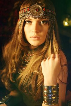 a woman with long hair wearing bracelets and jewelry