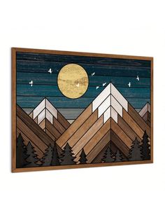 a wooden wall hanging with mountains and trees in front of a full moon at night