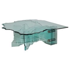 a glass coffee table with metal legs and an abstract design on the top, against a white background