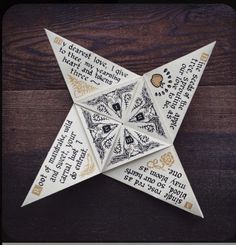 an origami star with words written on it sitting on top of a wooden table