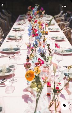 a long table with flowers and plates on it