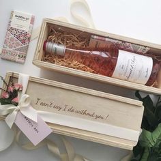 two bottles of wine in a wooden box next to some flowers and a note that says i can't say i do without you