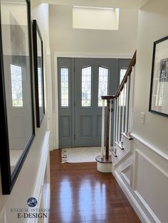 an empty hallway with wood flooring and framed pictures on the wall next to it