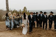 a bride and groom walking with their wedding party