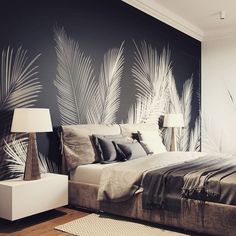 a bedroom with palm leaves painted on the wall next to a bed and night stand