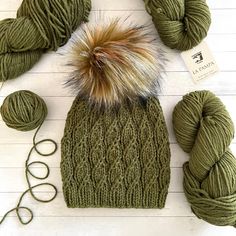 a green hat and two skeins of yarn