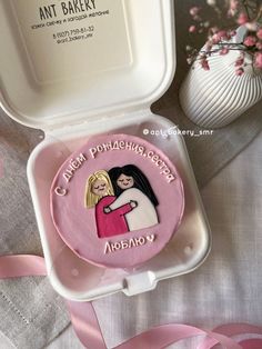 there is a cake in the shape of a box with a picture of two women on it