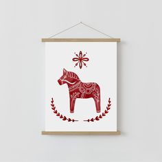 a red and white poster hanging on a wall next to a wooden frame with an ornament in the shape of a horse