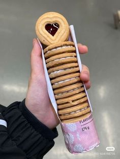 a person holding a stack of cookies in their hand with a heart shaped cookie on top