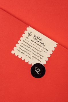 a red envelope with a black and white sticker on the front that says wine journal