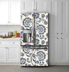 a blue and white floral refrigerator freezer in a kitchen with white cabinetry, counter tops, and cabinets