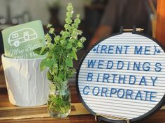 a vase filled with flowers next to a sign that says rent me wedding's birthday corporate