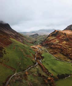 an aerial view of a valley with mountains in the background