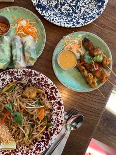 three plates of food on a table with utensils and spoons next to them