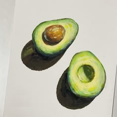 an avocado cut in half sitting on top of a piece of white paper