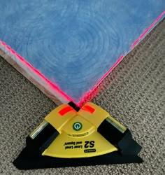 a yellow and black floor sander laying on top of a carpet