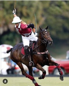 a polo player is riding a horse on the field with his arm in the air