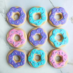 six doughnuts with different colored frosting and sprinkles on them