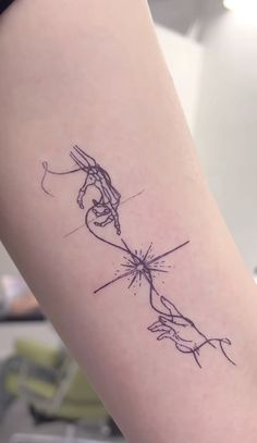 a woman's arm with a tattoo on it that has two hands holding each other