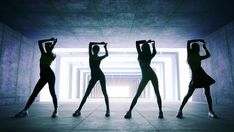 three women are standing in the dark with their arms raised