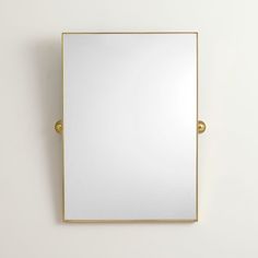 a square mirror mounted on the wall