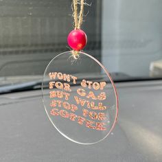 a glass ornament hanging from the dashboard of a car that says, won't stop for gas but will stop for coffee