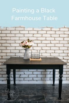 a black table with flowers on it and the words painting a black farmhouse table above it