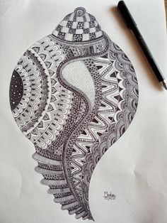 an intricately designed piece of paper with a pen on it