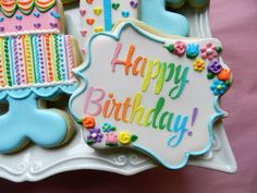 decorated birthday cookies are displayed on a plate