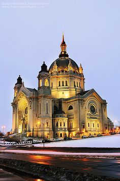 a large building with a clock on it's side in the middle of winter