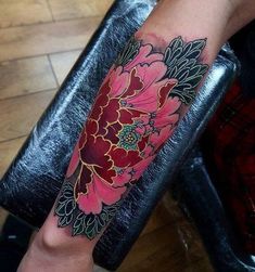 a woman's arm with a flower tattoo on the left side of her leg