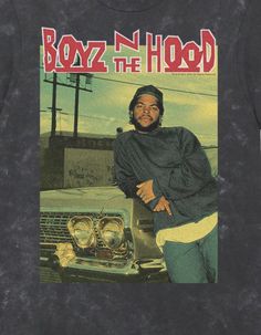 a man standing next to a car wearing a black shirt with the word boyz n'hood on it