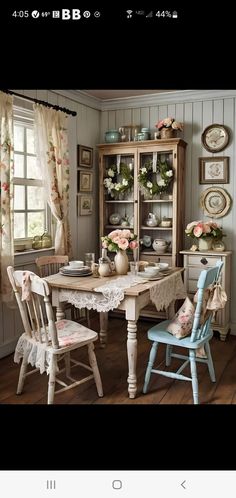 a dining room table with two chairs and a china cabinet