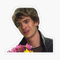 the young man is holding flowers in his hand