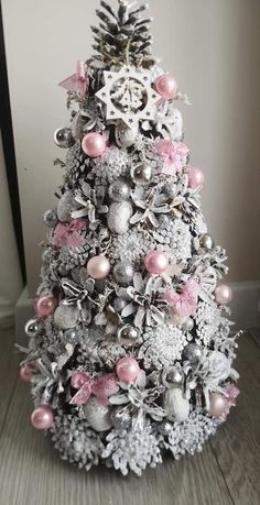 a silver and pink christmas tree with ornaments