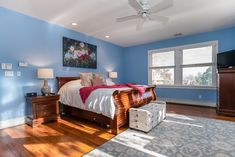 a bedroom with blue walls and hardwood floors