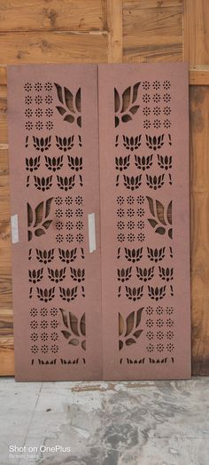 two wooden doors with laser cut designs on the outside and inside, one is pink