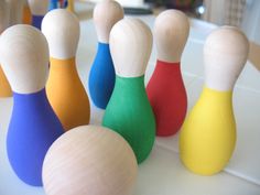 several wooden toy bowling pins lined up in a row on top of a white table