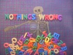 there is a skeleton with letters and numbers in front of it