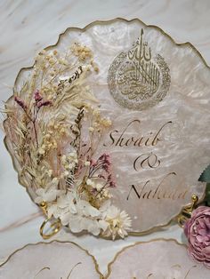 two plates with flowers on them sitting next to each other and the words sharaq & nabila written in arabic