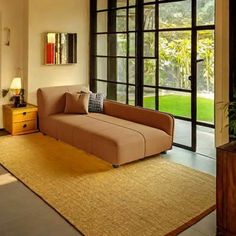 a living room filled with furniture and lots of glass doors leading to a lush green yard