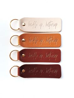 three leather keychains with words on them