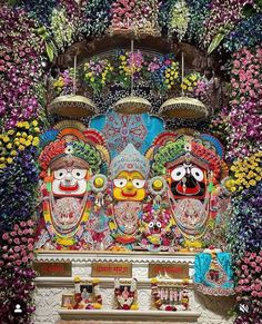 an elaborately decorated shrine with flowers and masks on it's face, surrounded by other decorations