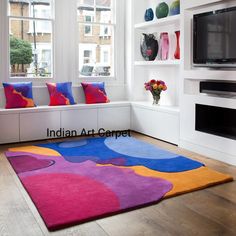 a living room filled with furniture and a flat screen tv on top of a wooden floor