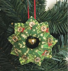 a green christmas ornament hanging from a tree