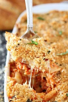 a close up of a plate of food with a spoon in it and some bread crumbs on the side