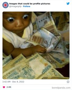 a baby is sitting on top of money and looking at the camera with big eyes