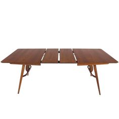 a wooden table with four legs and two leaves on the top, against a white background