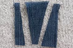 two pieces of blue jeans sitting on top of a carpet