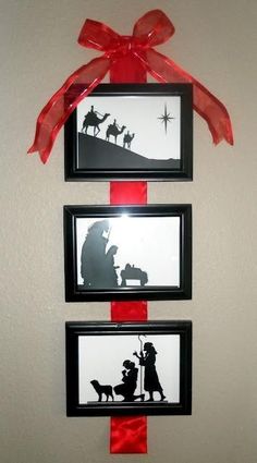 three framed pictures hanging on the wall with red ribbon around them, depicting nativity